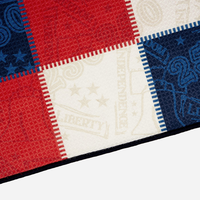 PXG stars and stripes players golf towel with patchwork colors of blue, white, and red on a white background