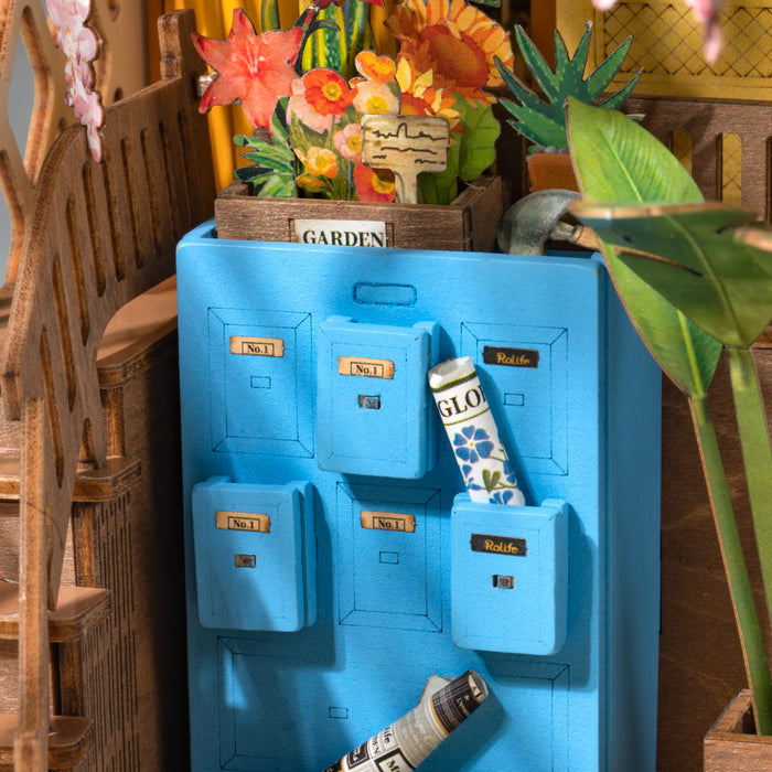 Rolife miniature kitchen back panel close up showing blue painted door with paint tubes and flower vase