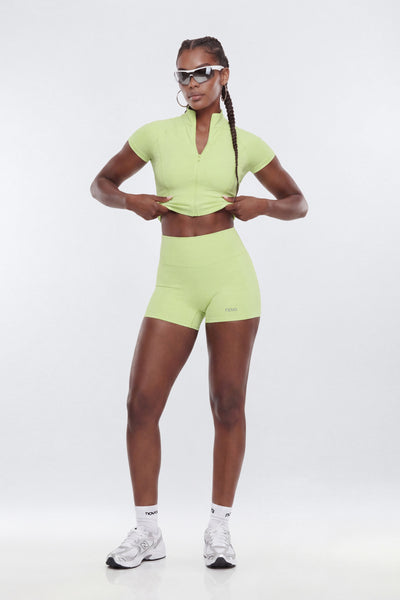 Person wearing a bright green athletic outfit on a white background
