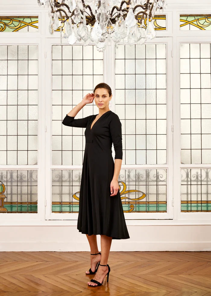 Woman models black V-neck dress with sleeves