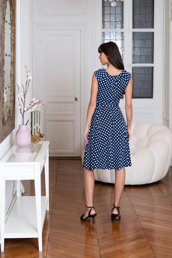 Model wears sleeveless polka dot dress
