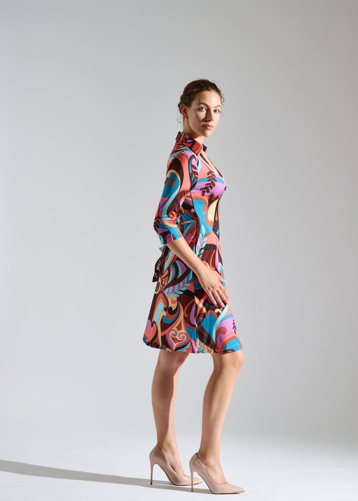 Side view of woman wearing an Elegance Miss abstract print wrap dress