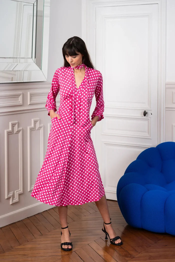 Model dons a pink and white polka dot dress