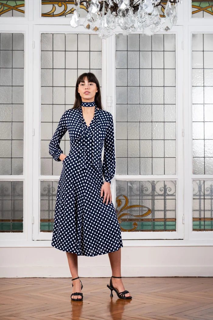 Model wears an Elegance Miss navy blue polka dot dress