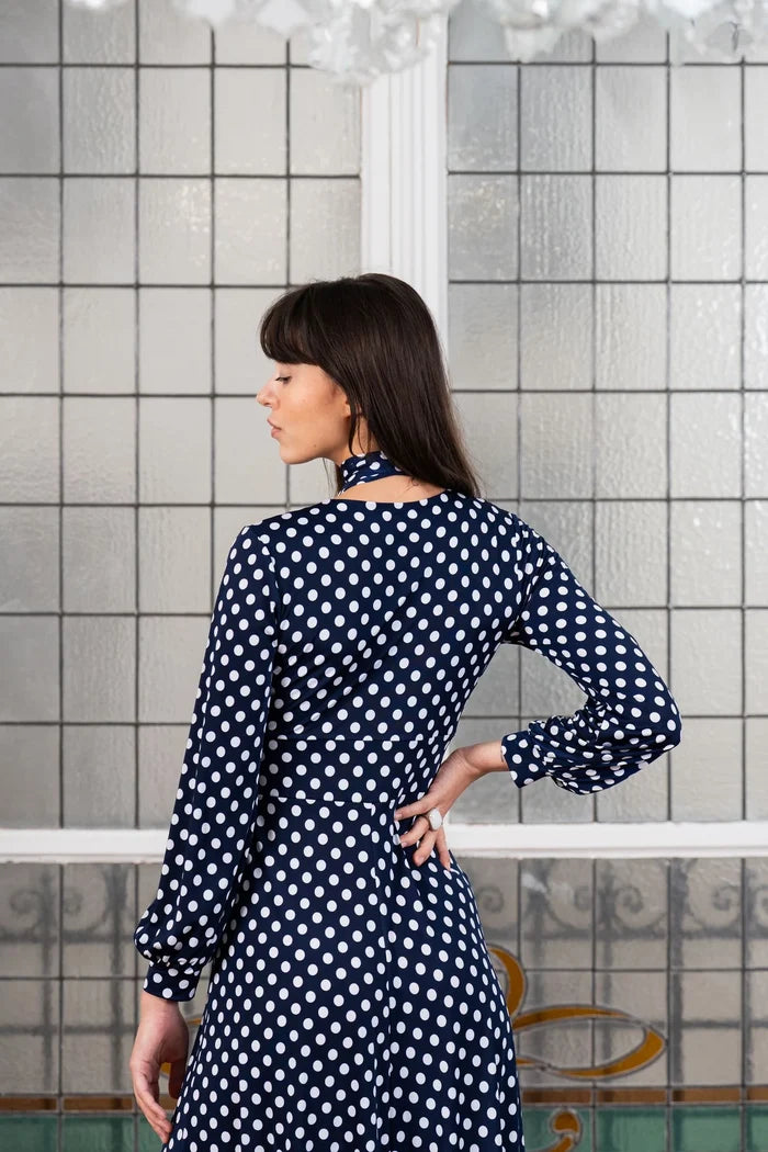 Woman models navy blue polka dot midi dress
