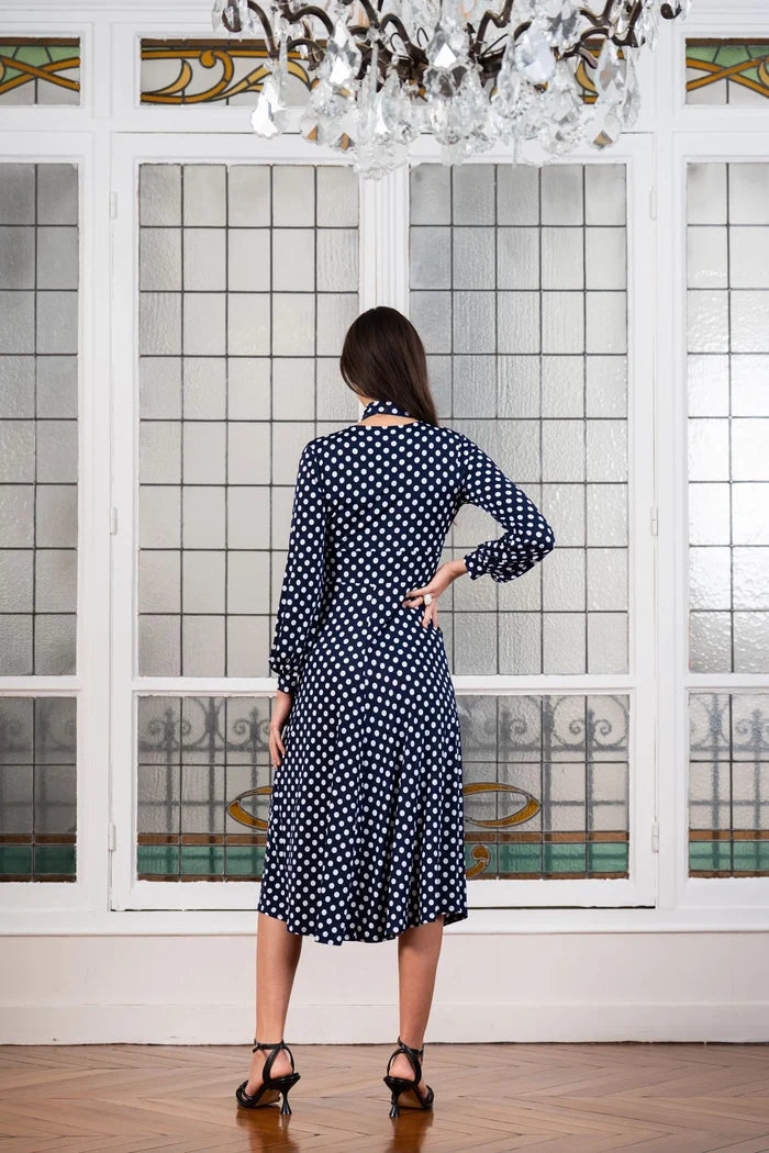 Model wearing a navy blue polka dot dress