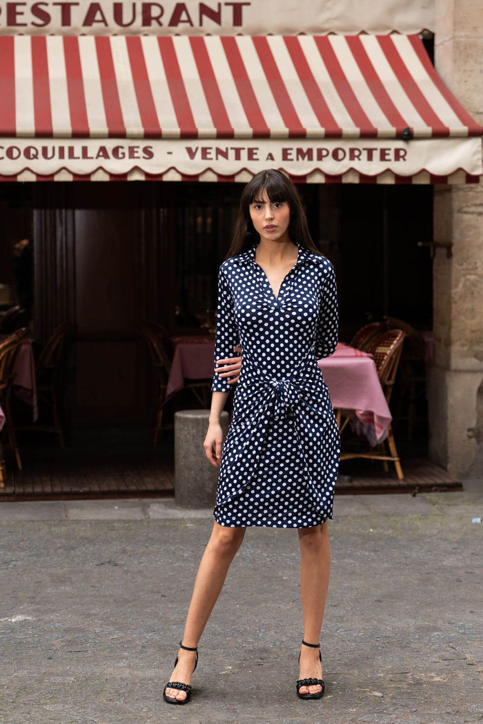 Model poses in knot-waist dress in a Paris street