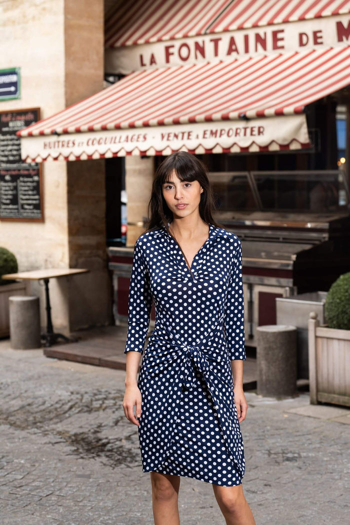Model wears polka dot fitted dress in Paris