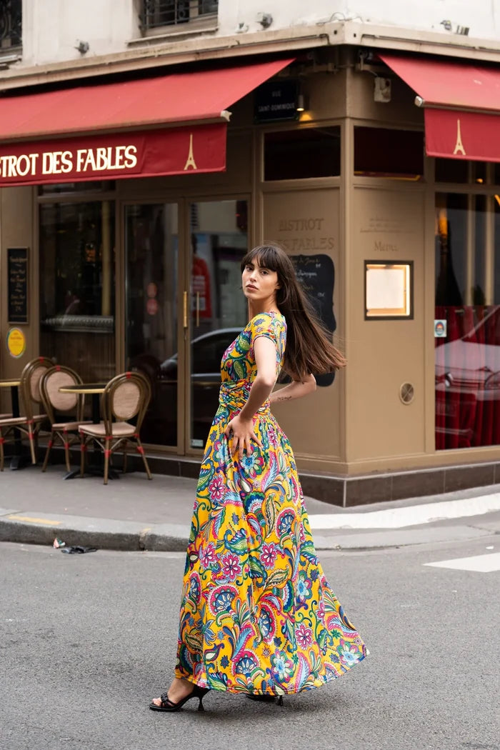 Woman wears a long bohemian dress on the streets of Paris
