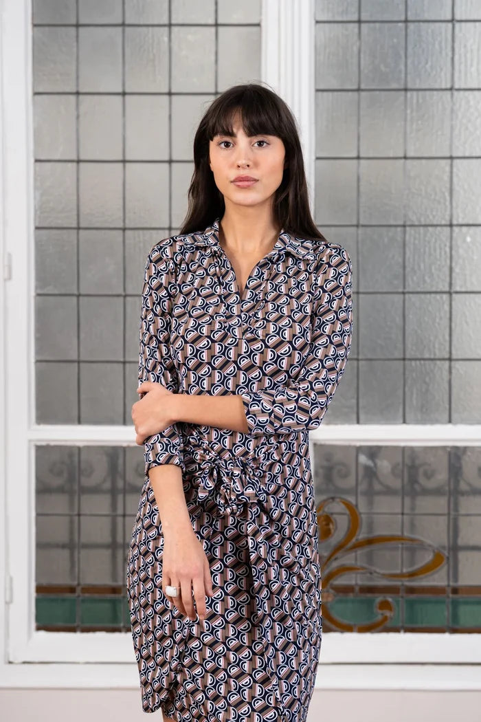 Woman wears a graphic print dress in a Paris apartment