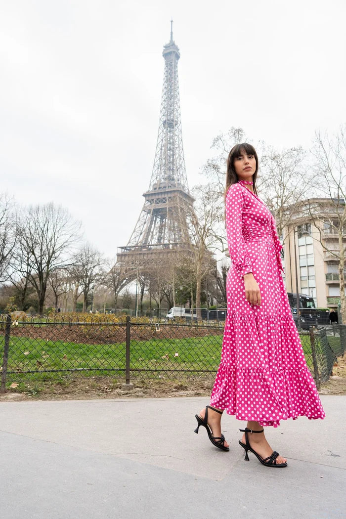 Woman wearing a wrap polka dot dress in front of the Eiffel Tower