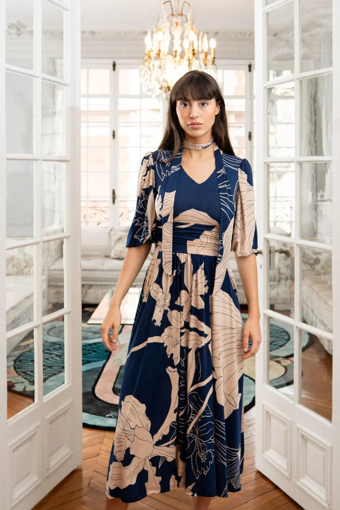 Model wears a blue and beige dress