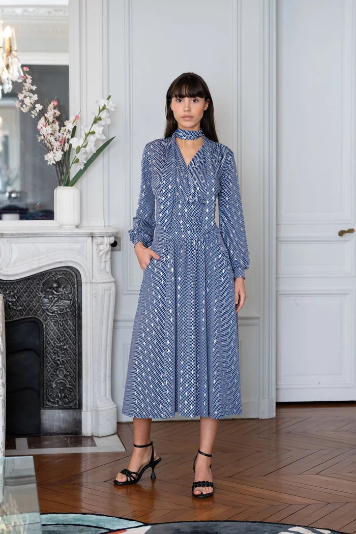 Woman models an Elegance Miss bishop sleeve dress in Paris