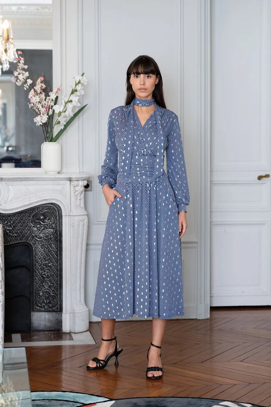 Woman models an Elegance Miss bishop sleeve dress in Paris