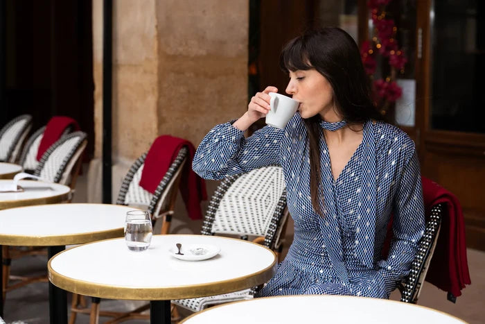 Model drinks coffee wearing bishop sleeve dress