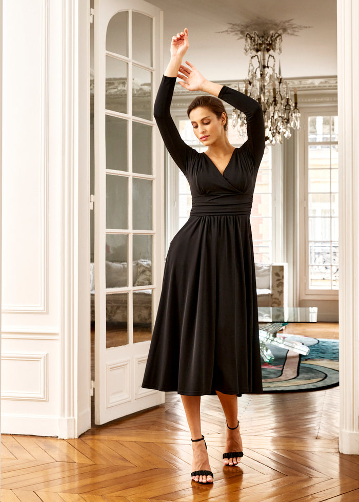 woman models black V-neck dress