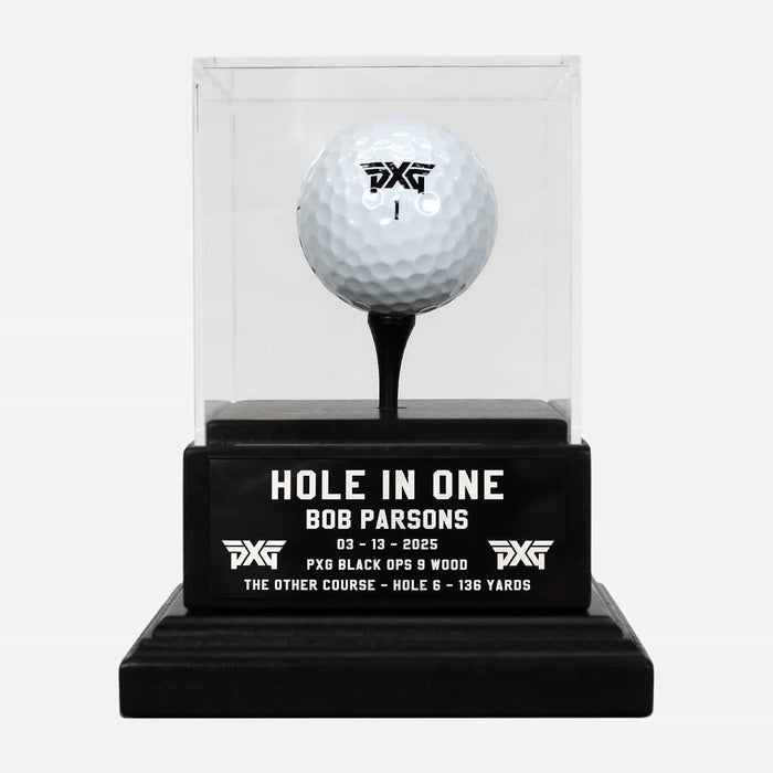 PXG black hole in one trophy that holds a pxg golf ball on a tee inside of the trophy box on a white background