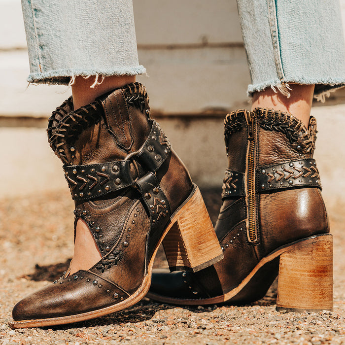 Black JETSON western booties with intricate topstitching, studded straps, chevron accents, and stacked leather heels.