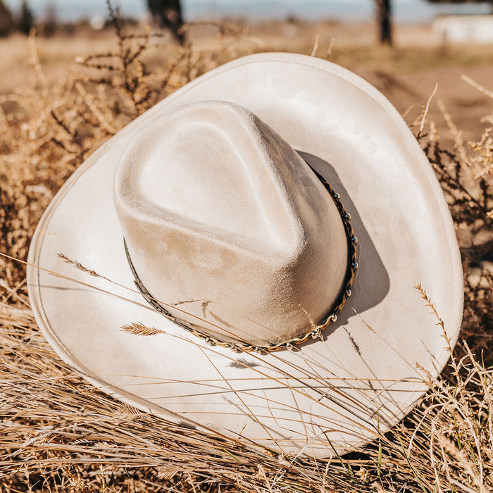 Beige JONES western wide brim hat with a teardrop crown, braided leather band, and structured faux suede finish.