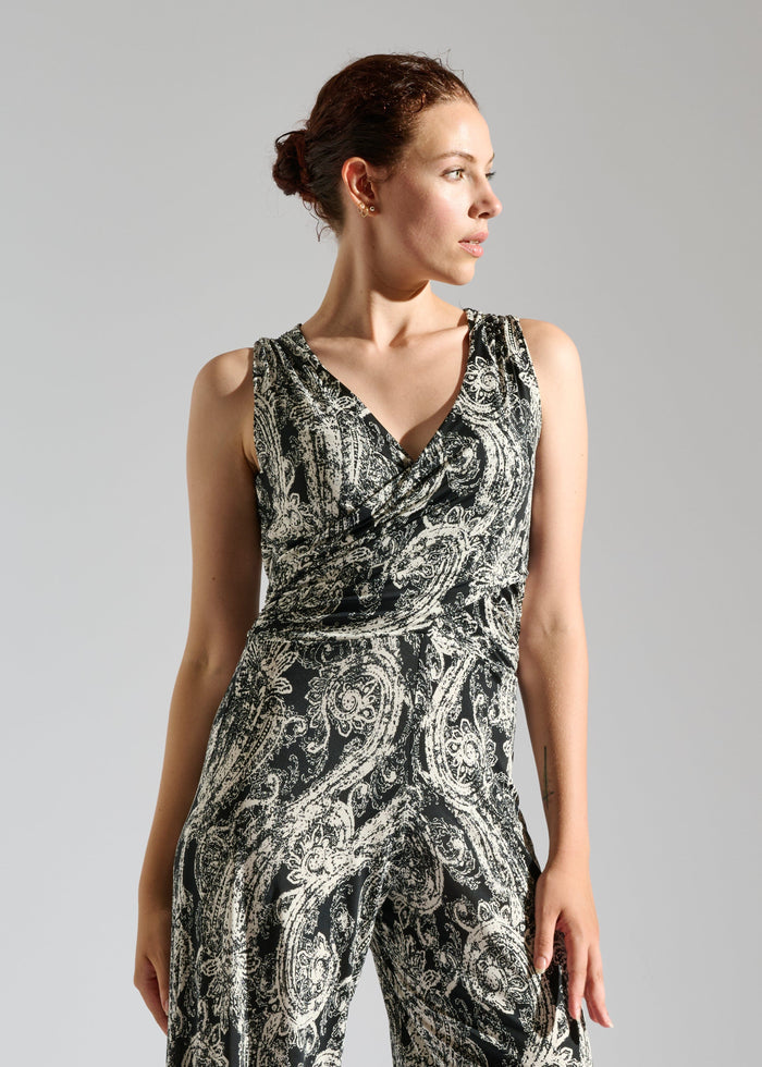 Close up of Elevran black sleeveless jumpsuit with elegant gold pattern.