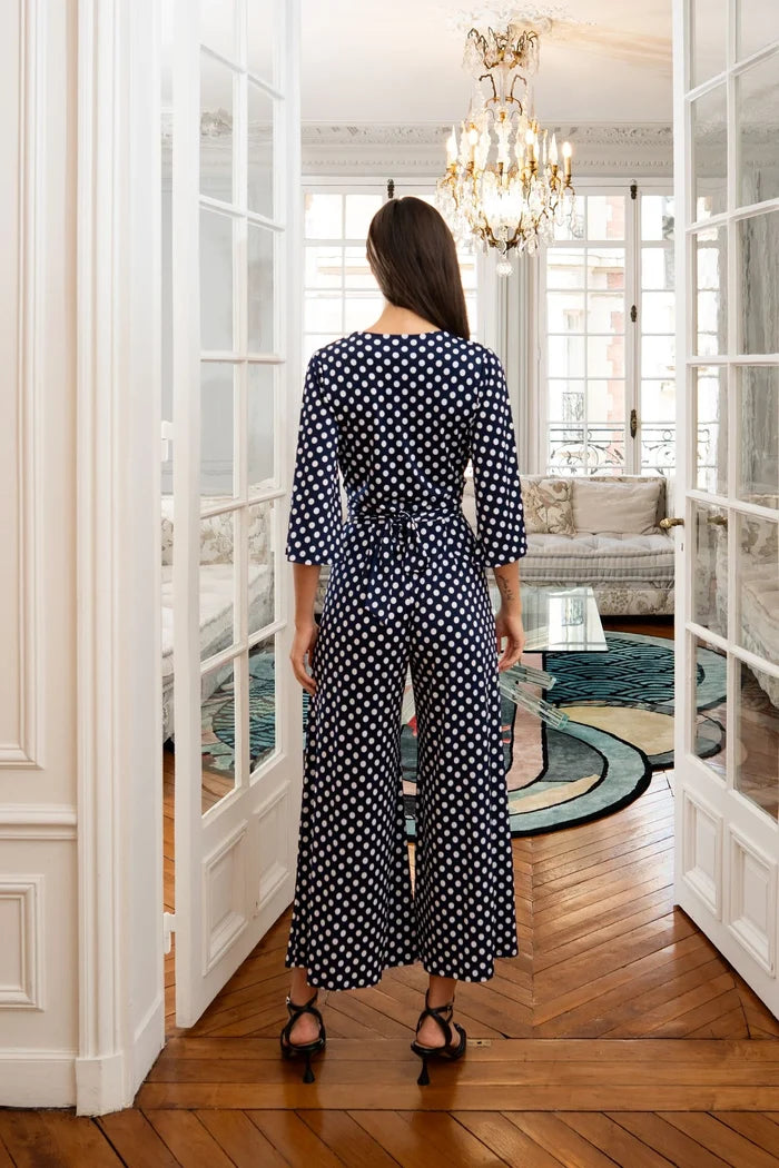 Woman models an Elegance Miss jumpsuit with scarf in a Paris apartment