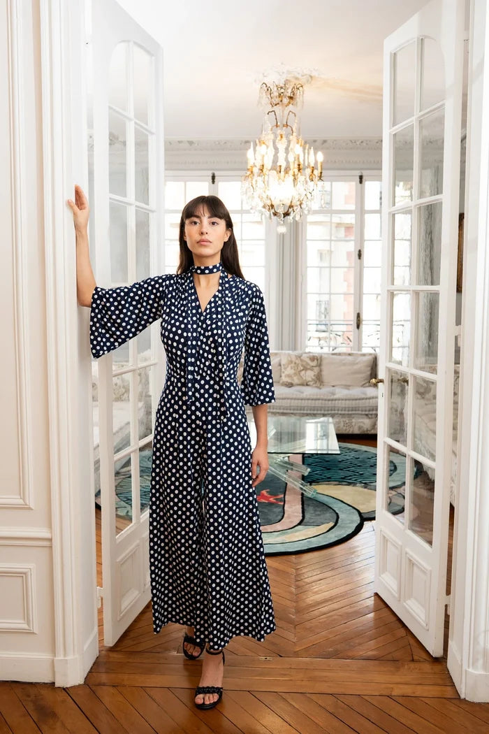 Woman models navy polka dot jumpsuit