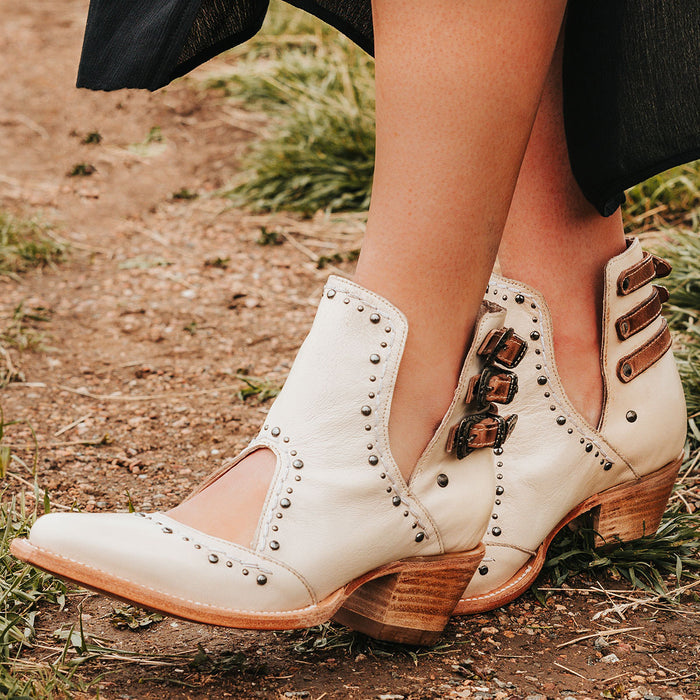 Beige MELODY leather booties with V-cut sides, studded trim, and western buckles on a stacked heel.