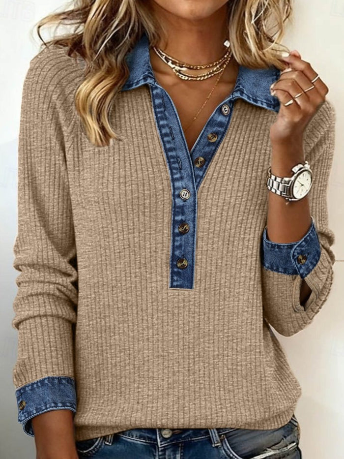 Person wearing a beige sweater with blue denim collar and cuffs against a neutral background