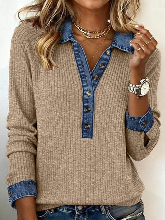 Person wearing a beige sweater with blue denim collar and cuffs against a neutral background