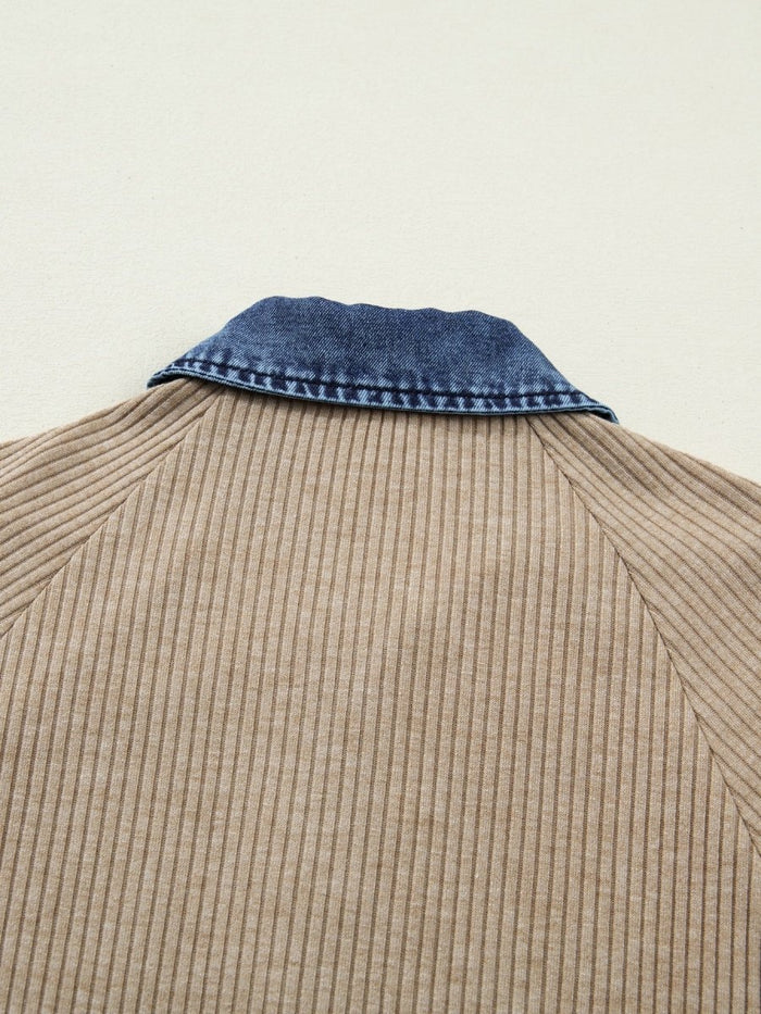 Close-up of a beige corduroy shirt with a blue denim collar on a light background