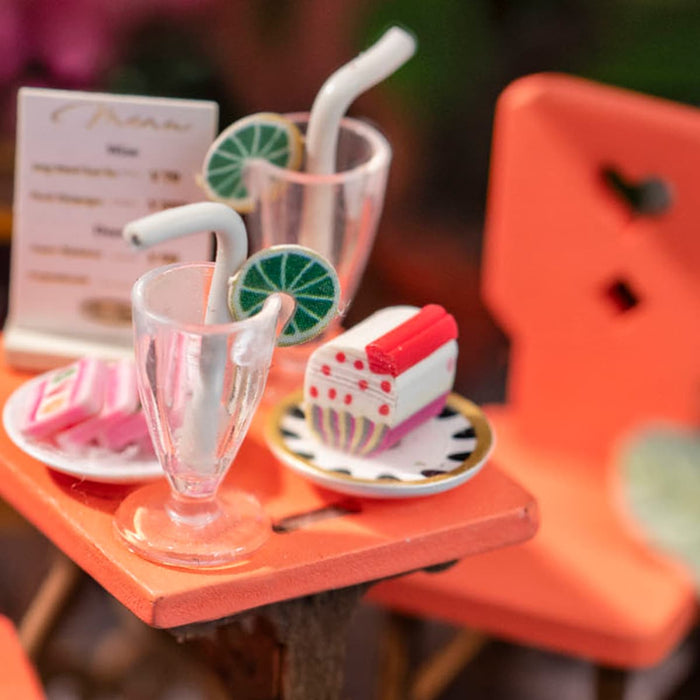 Rolife miniature cafe dessert table with strawberry cake and milkshake glasses on bright orange surface