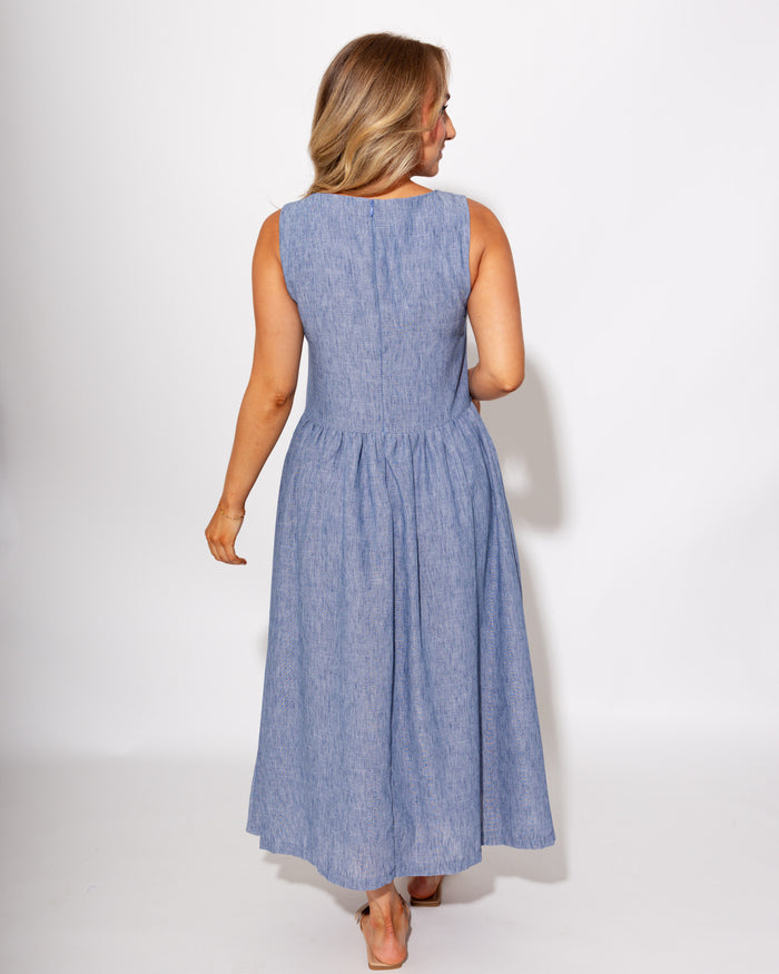 Light blue sleeveless pleated midi dress styled with sandals, summer outfit at Gaudie & Co