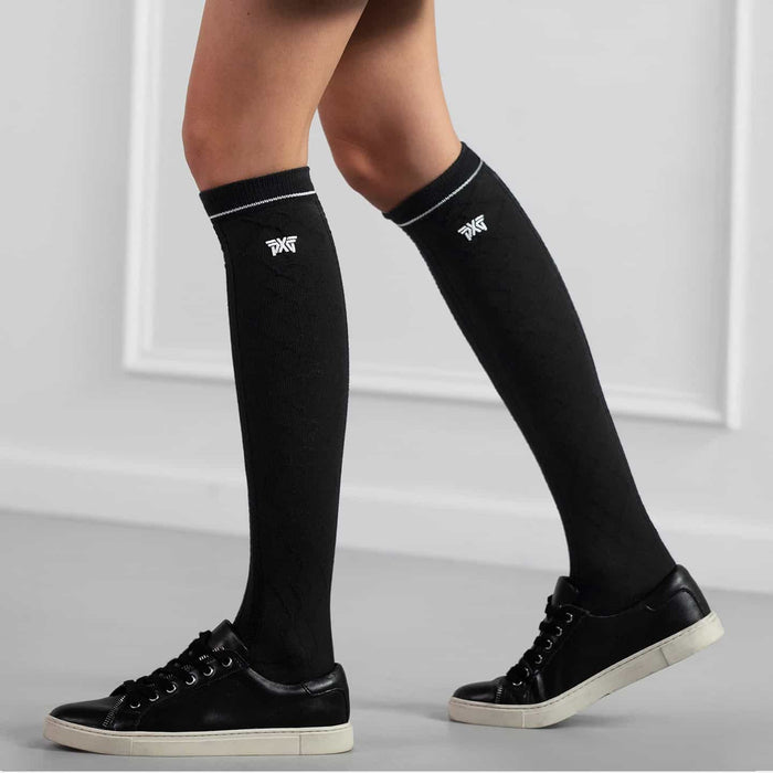 PXG women's black jacquard knee golf socks with a white PXG logo on a white background