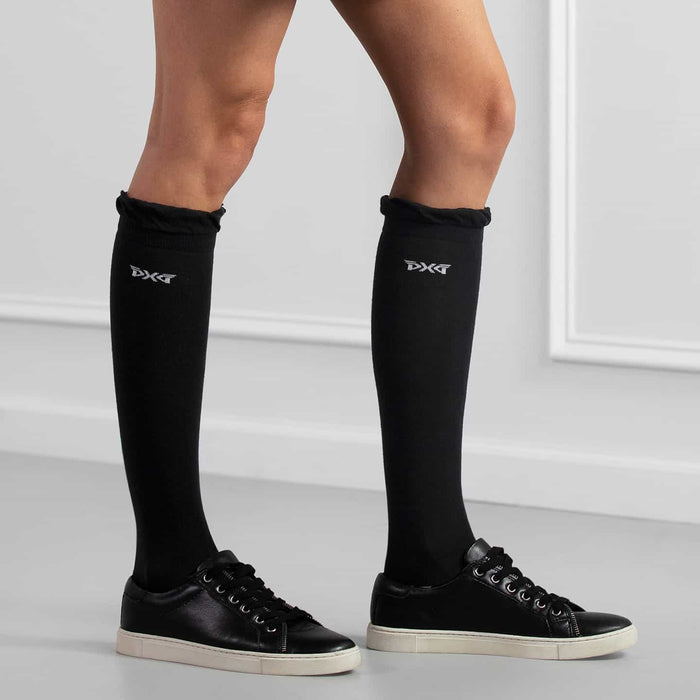 PXG women's black ruffle knee golf socks with ruffles at the top and a white PXG logo on a white background