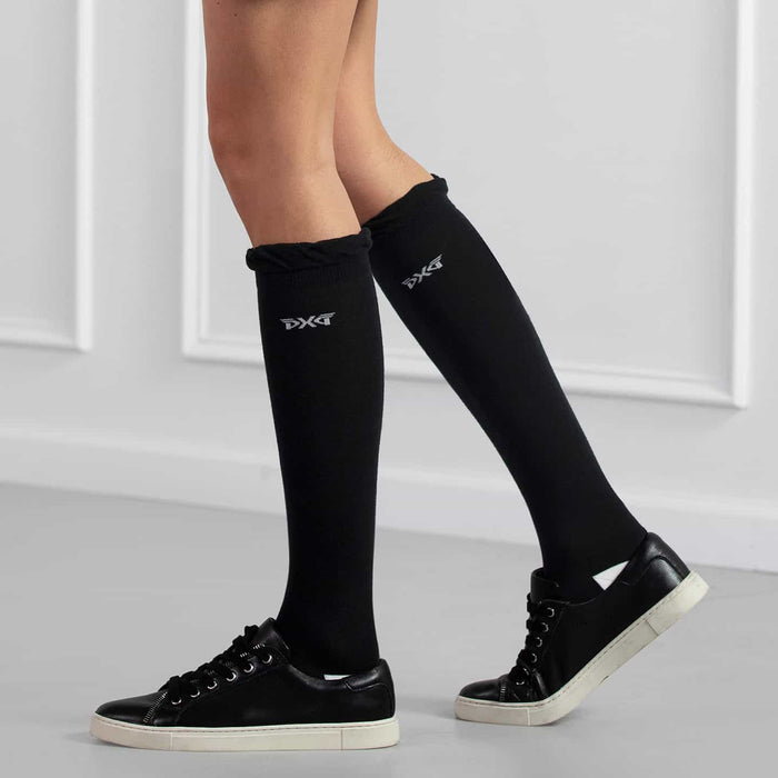 PXG women's black ruffle knee golf socks with ruffles at the top and a white PXG logo on a white background